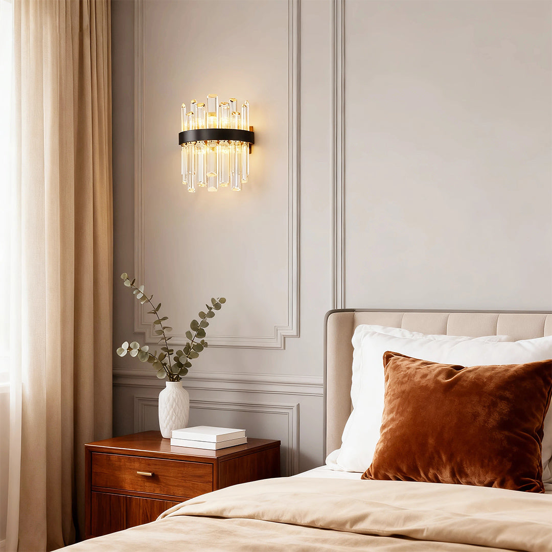 Luxury crystal chandelier creating warm ambiance in cozy bedroom with rust-colored bedding