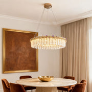 Luxury dining room featuring gold chandelier crystal and elegant table setting.