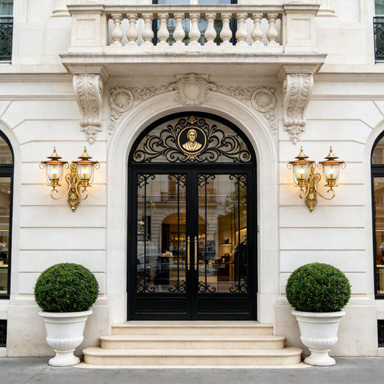 Luxury mansion entrance featuring elegant Copper Outdoor Wall Sconces beside ornate black double doors and stone facade.
