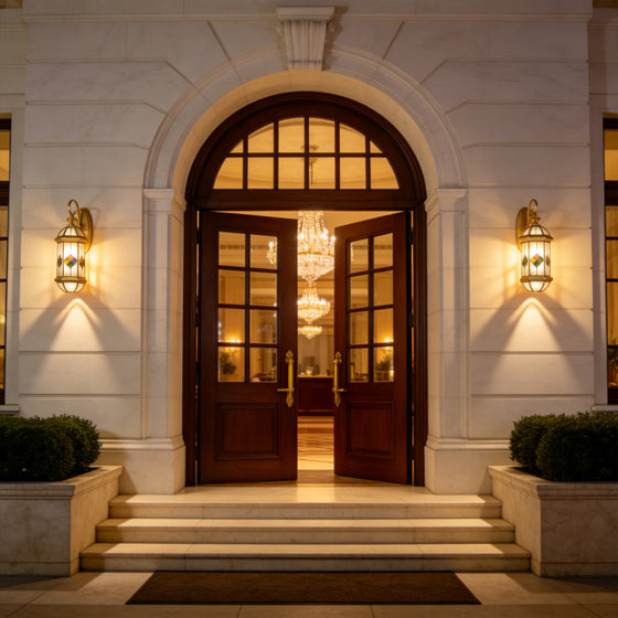 Elegant luxury home entrance illuminated with classic Outdoor Lantern Wall Lights beside an arched wooden doorway.