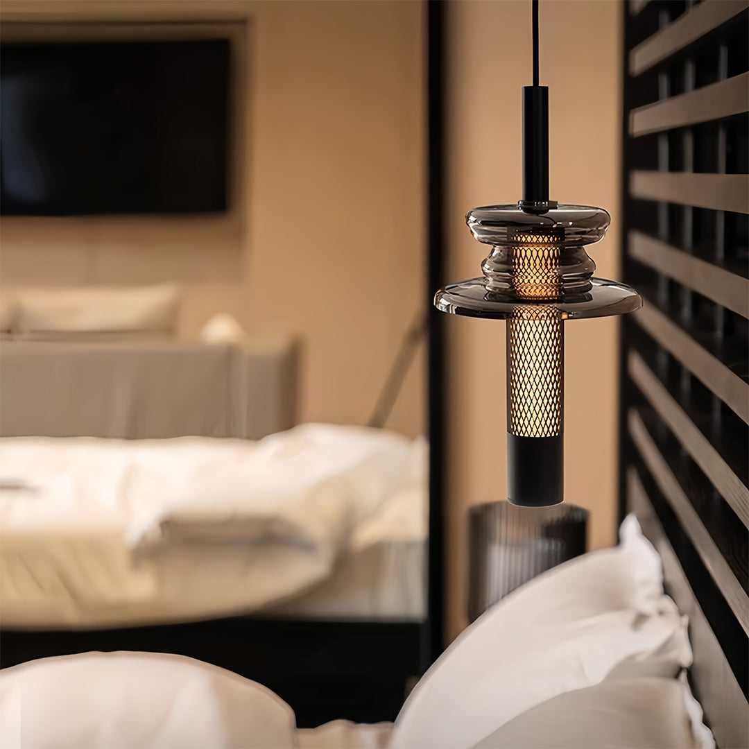 Luxury glass pendant lights illuminating modern bedroom with warm golden mesh detail at night