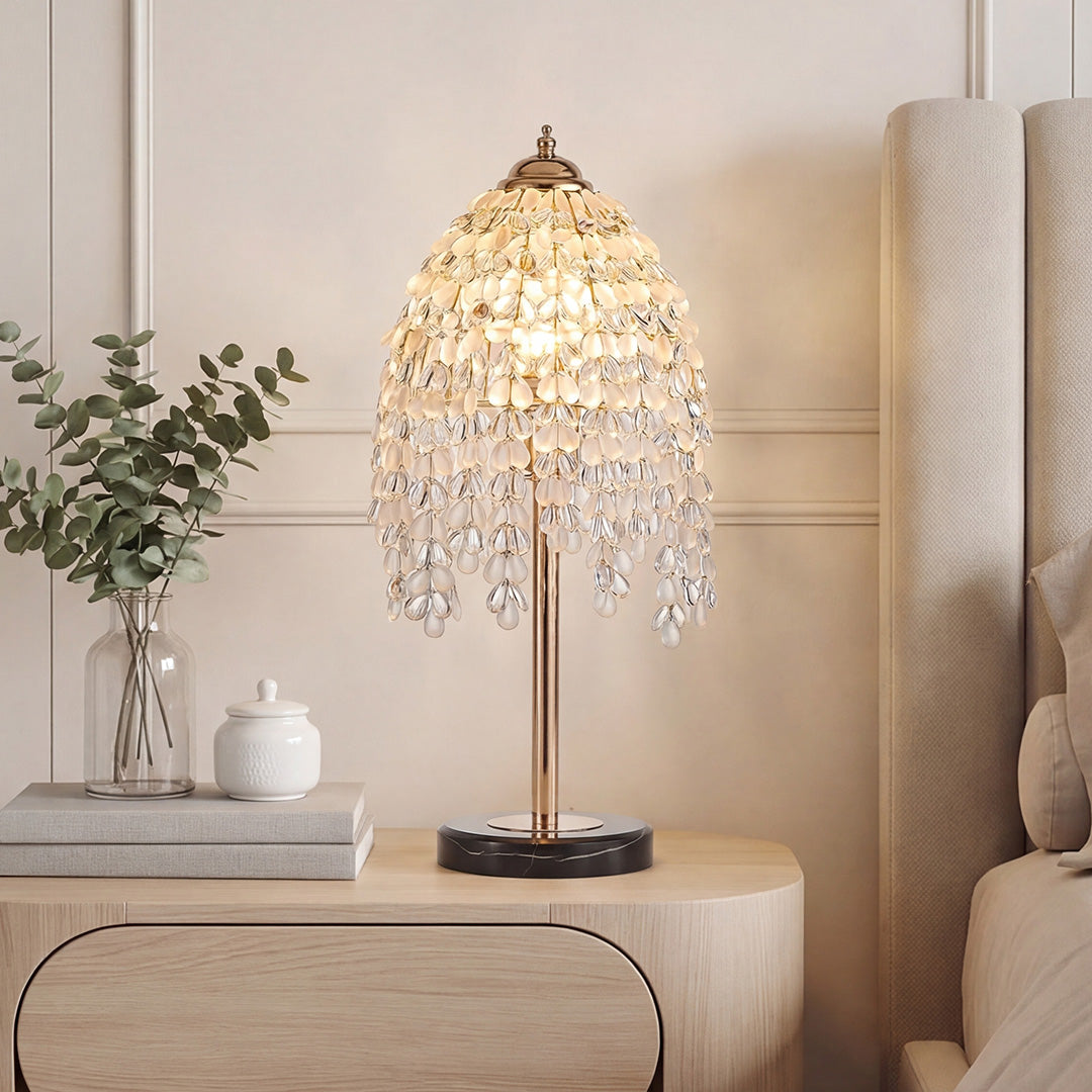Luxury gold bedside table lamp with cascading crystal tassels on a light colored wood nightstand