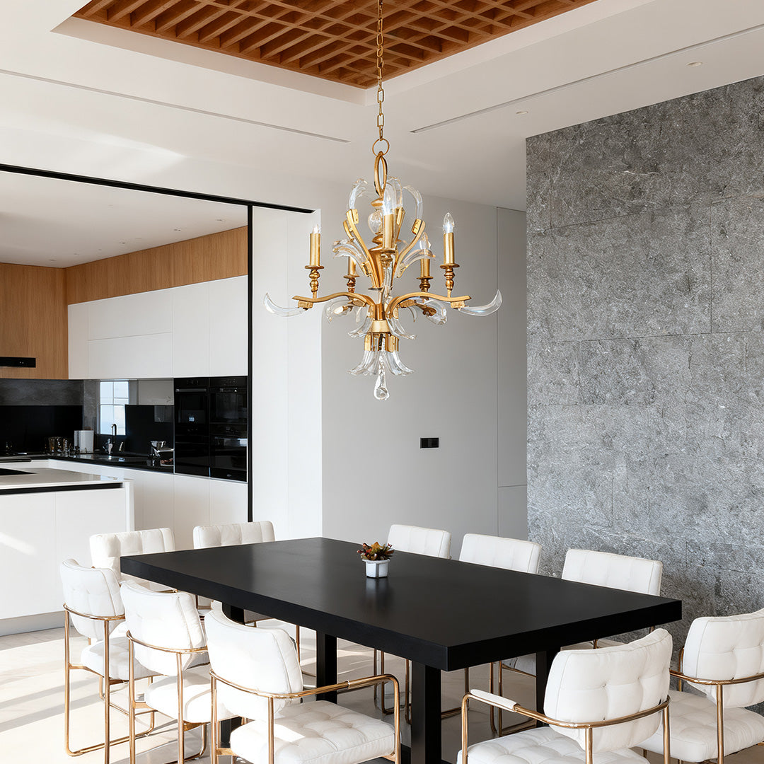 Luxurious dining area featuring a captivating gold and crystal chandeliers over a large, black dining table.