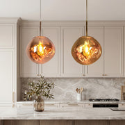 Stunning Melt pendant light duo in copper and gold over a luxury marble kitchen island desk.