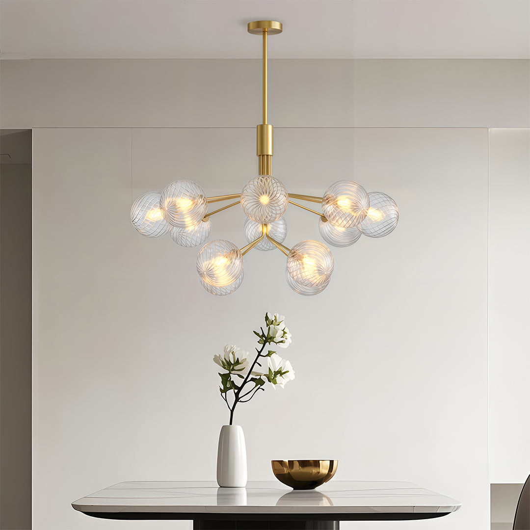 Luxury modern chandeliers with a gold finish, hanging in a bright and airy modern living space.