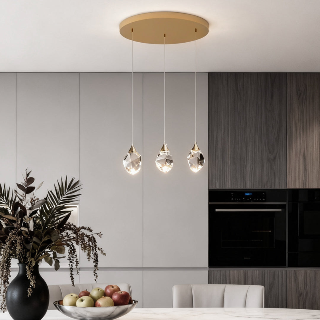 Luxury staircase chandelier featuring gold accents and crystal pendants in a contemporary kitchen.
