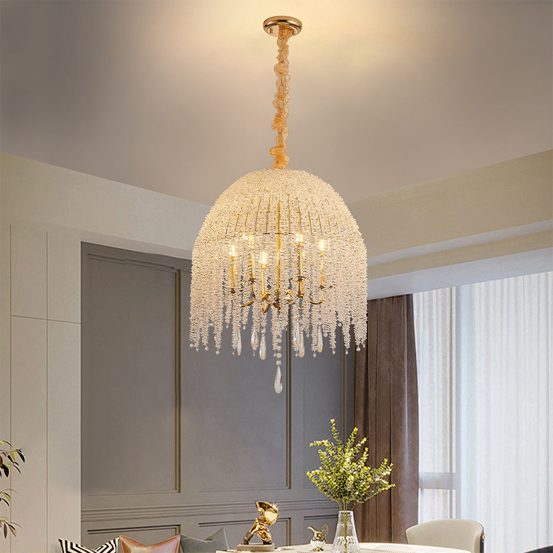 Elegant gold teardrop crystal chandelier hanging in a modern interior with soft neutral tones.