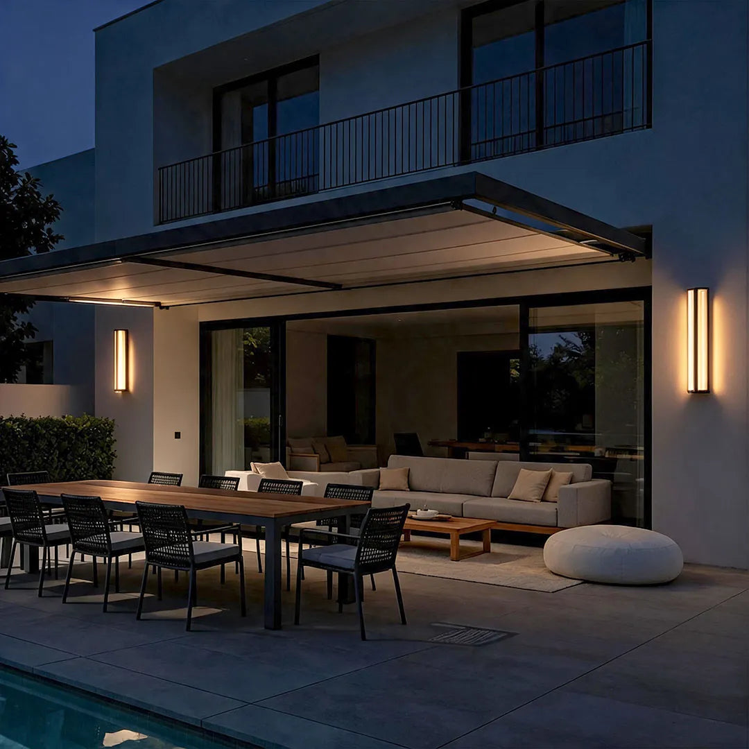 Wall mount outdoor lighting illuminating the exterior of a modern luxury home at night.