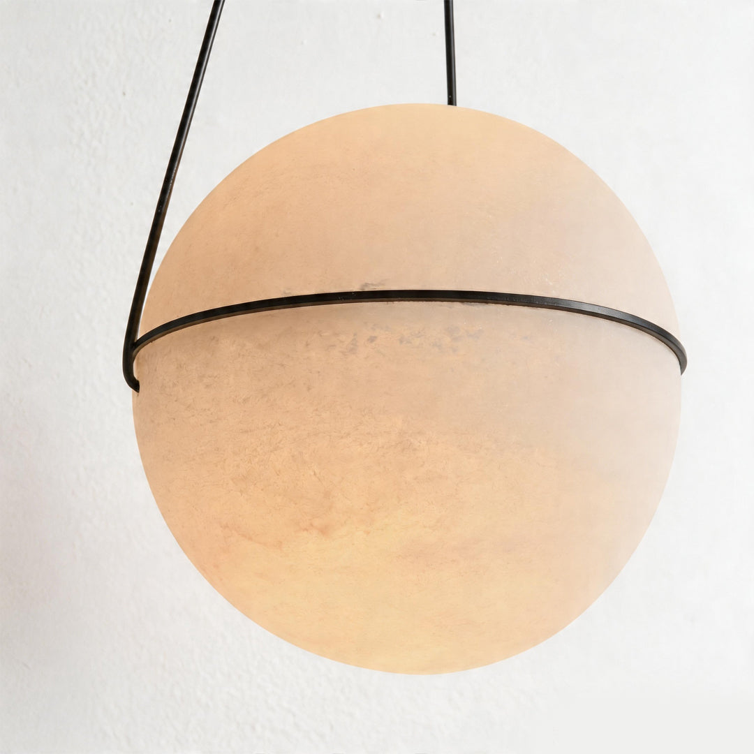 Macro detail of the warm frosted globe pendant light fixture shade with a black metallic ring.