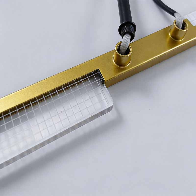 Macro detail of wire attachment and acrylic edge on the metal frame of Gold cross ceiling light