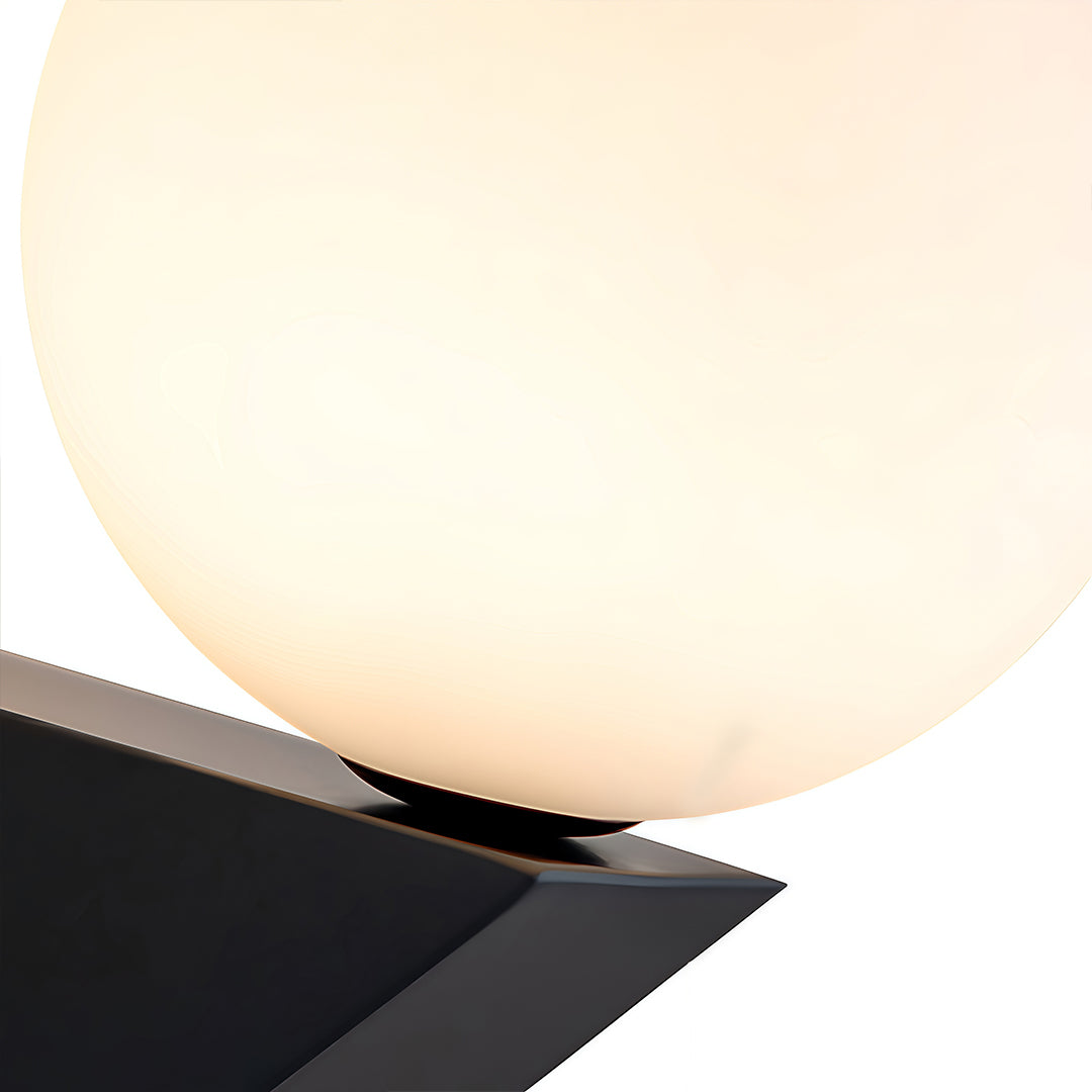 Macro shot of the large frosted globe wall light, emphasizing the soft, diffused light and the smooth black mounting detail.