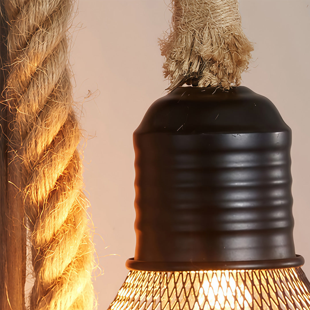 Macro shot of the thick natural rope detail and dark metal socket of the rustic wall light fixture.