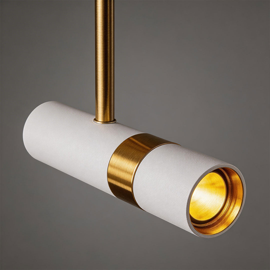 Detailed macro view of white adjustable cylindrical pendant light with inner gold reflector cup.