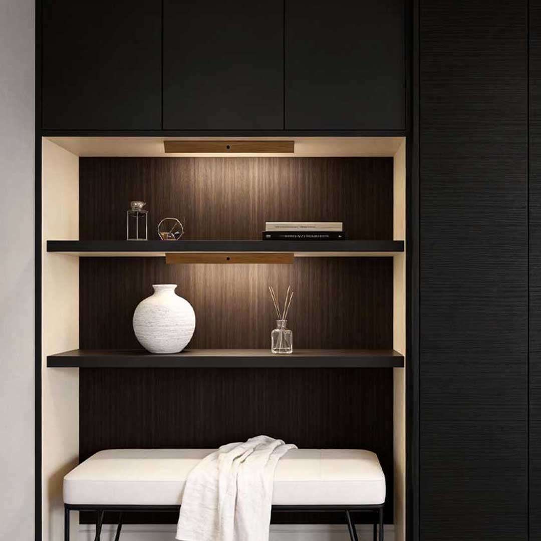 Magnetic motion sensor light casting warm light in a stylish closet with shelves.