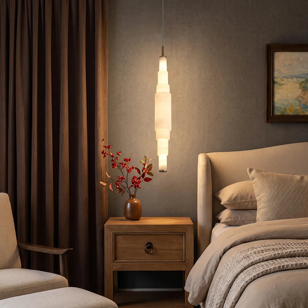 Marble chandelier hanging beside a bed in a warm and cozy bedroom interior.