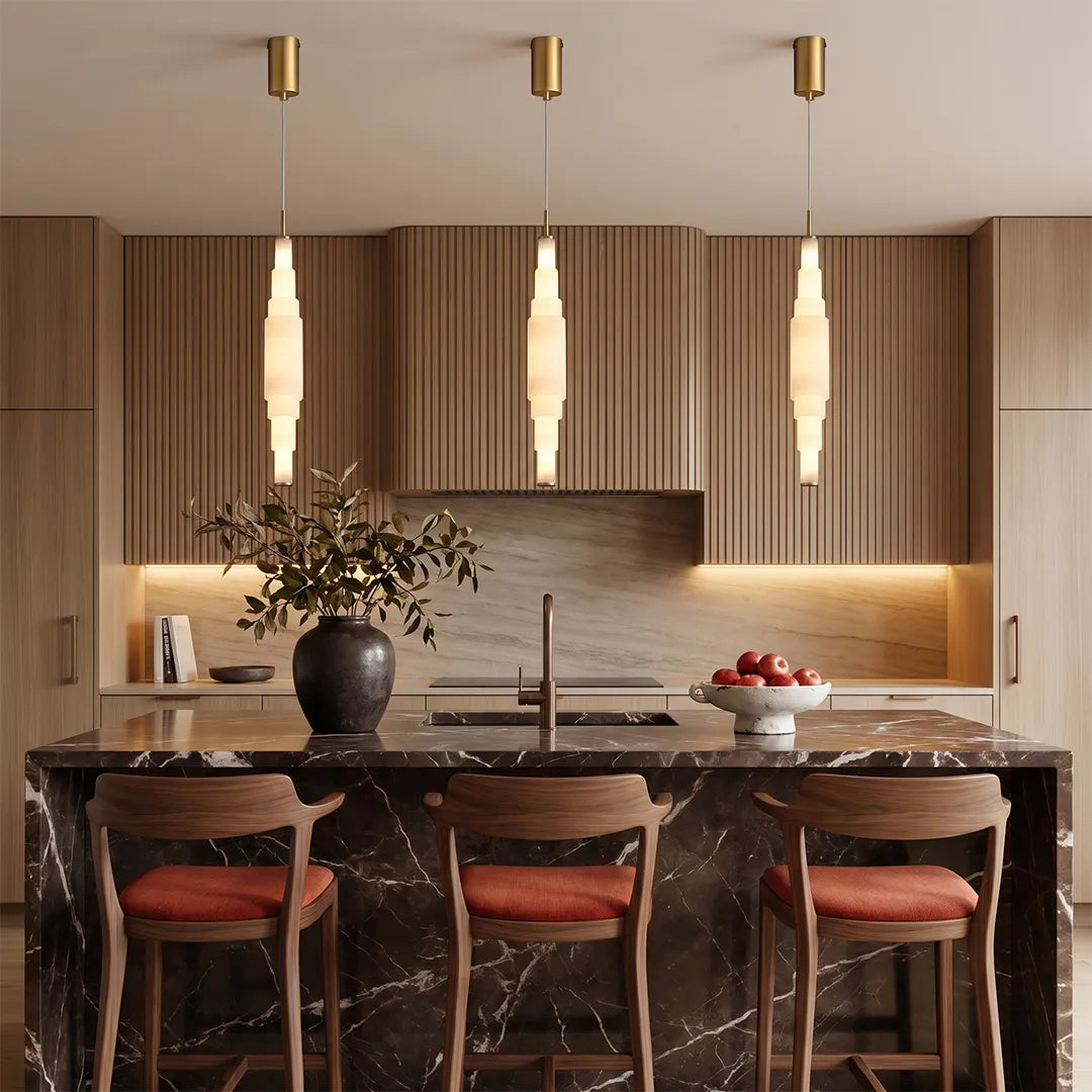 Marble chandelier trio hanging above a kitchen island in a contemporary open-plan kitchen.