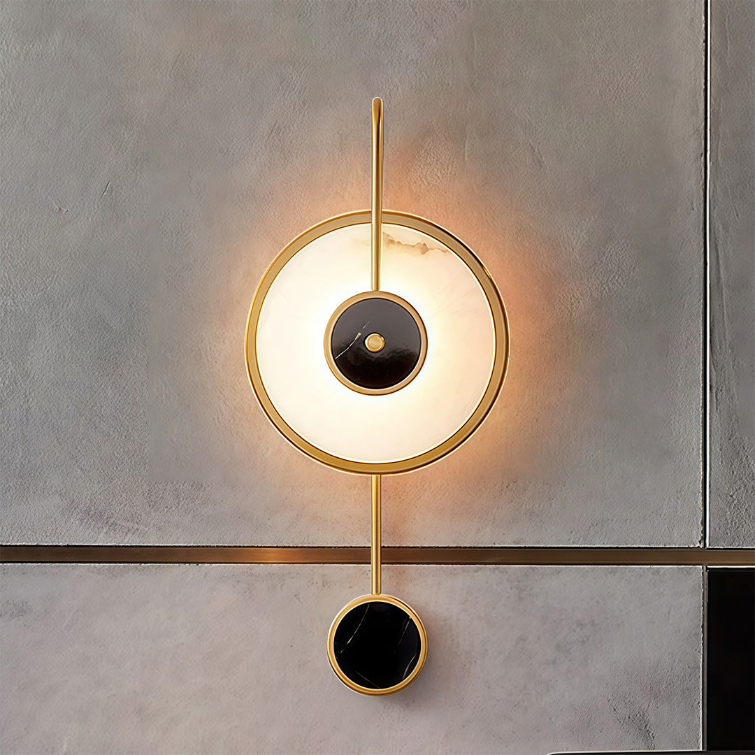 Marble wall light on textured concrete surface providing warm circular illumination and architectural drama