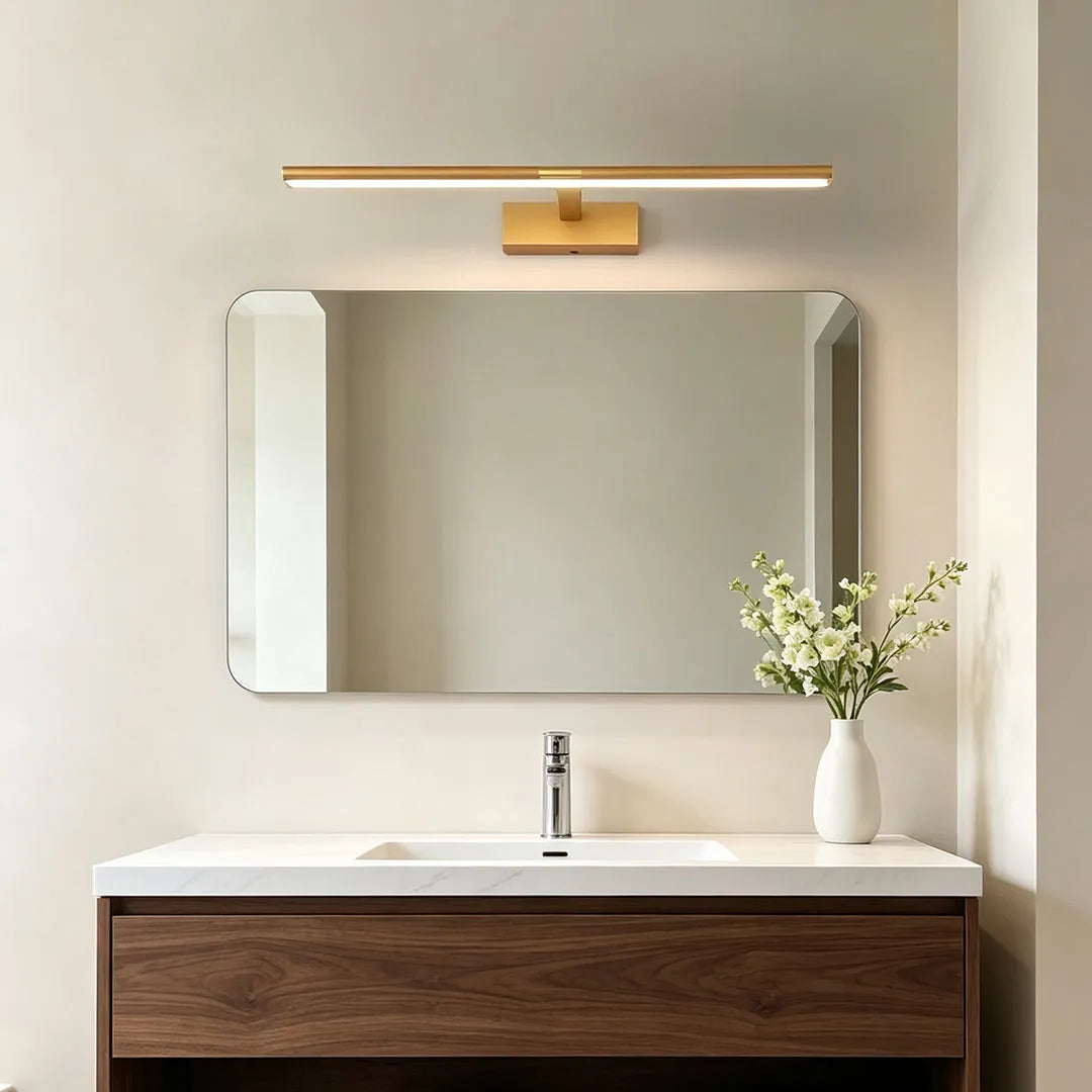 Master bathroom vanity lights in a warm gold finish above a mirror and floating wood vanity.
