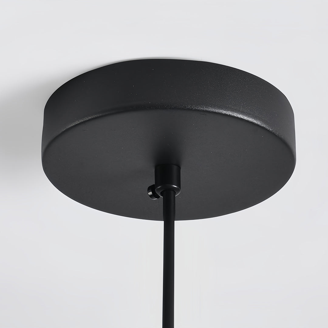 Matte black ceiling canopy and cord for a single gray pendant light installation, suitable for commercial spaces.