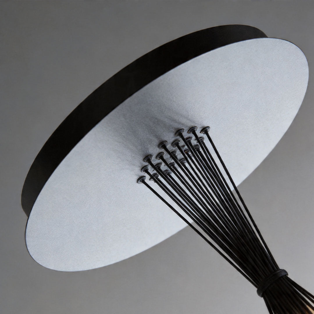 Close-up of matte black chandelier canopy and suspension cables with clean modern design.