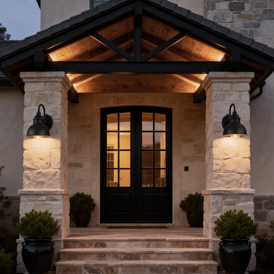 Matte black gooseneck light installed on stone columns at a covered entrance, adding welcoming and traditional exterior lighting.