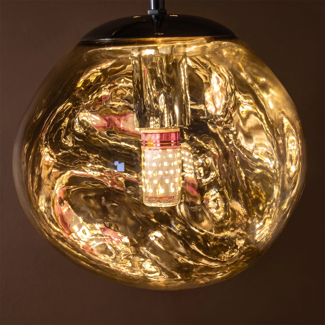 Illuminated melt LED pendant light with a reflective molten-glass effect and visible internal light source.