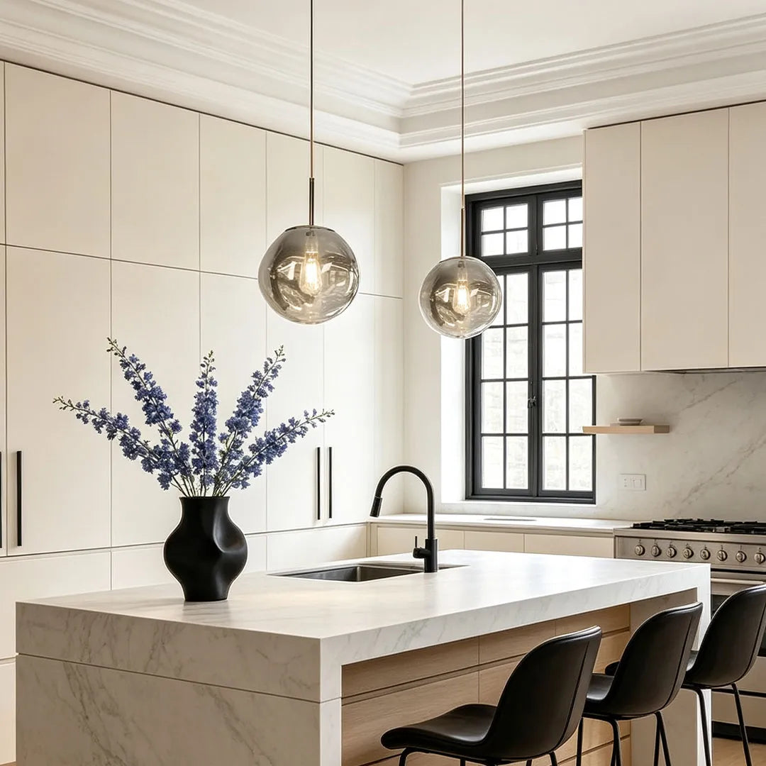 Melt pendant lights hanging above a white kitchen island in a bright contemporary kitchen.