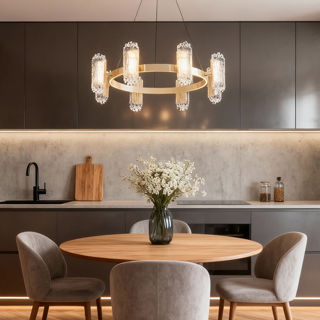Metal modern chandelier suspended above kitchen island with round marble table in contemporary open space