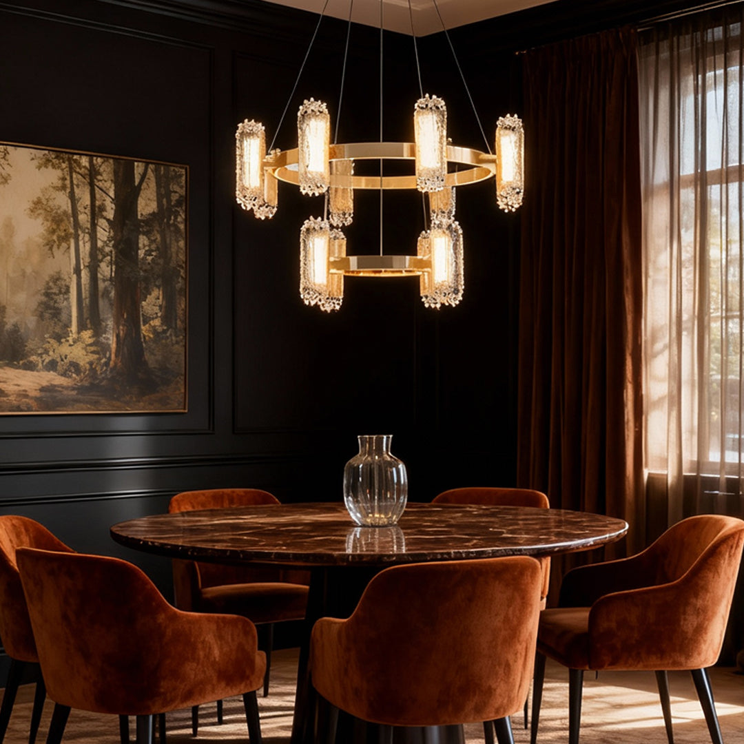 Metal modern chandelier providing warm lighting in luxurious dining room with velvet chairs and dramatic black walls