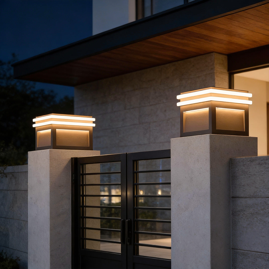 Metal pillar lights mounted on a concrete pillar, providing warm and contemporary outdoor illumination.