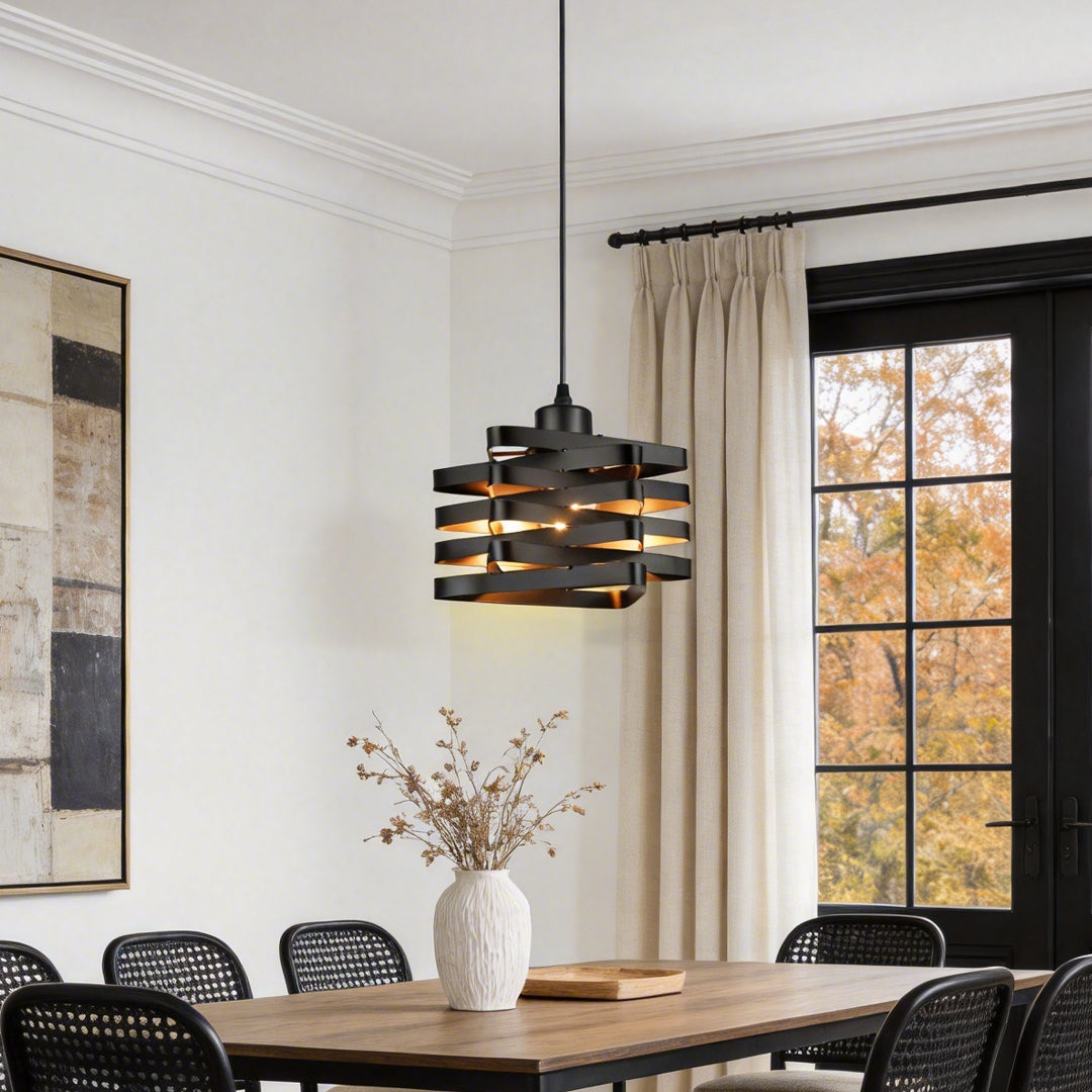 Metal ribbon pendant light hanging above dining table in classic interior.