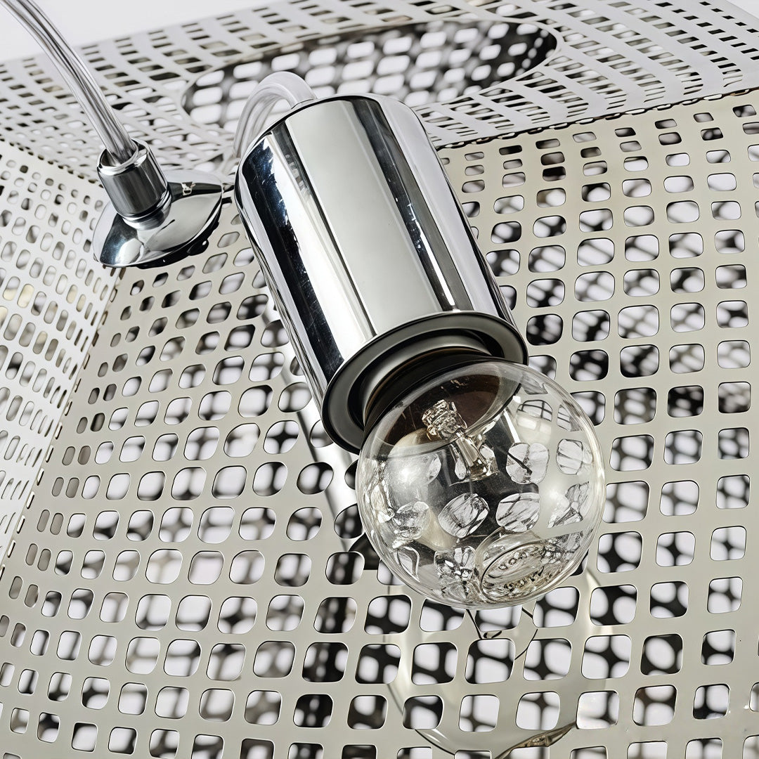 Close-up of metal shade pendant light socket and bulb inside a perforated geometric metal frame.
