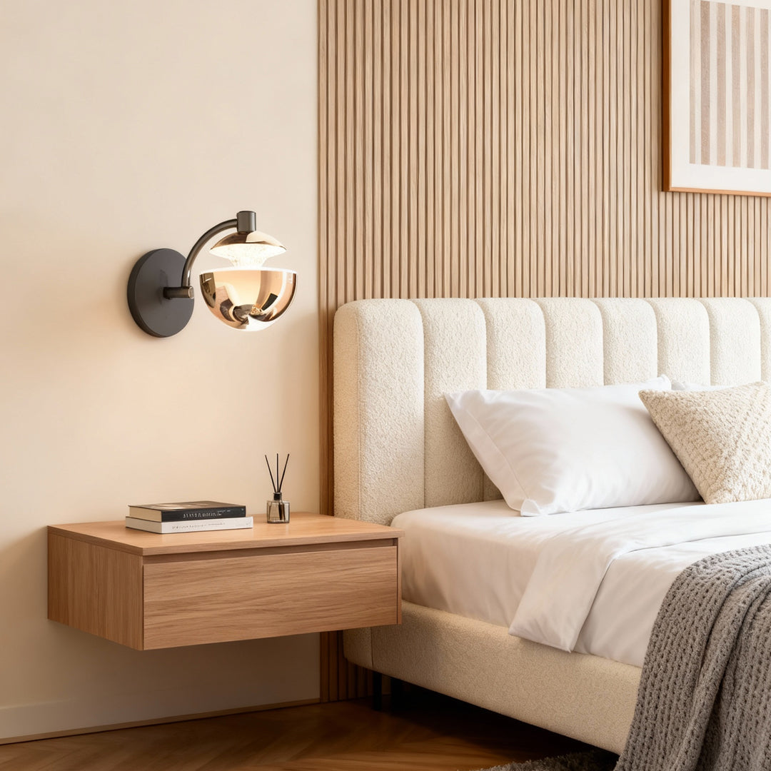 Metal wall sconce providing bedside lighting in bedroom with tufted headboard and wood slat paneling creating warm ambiance