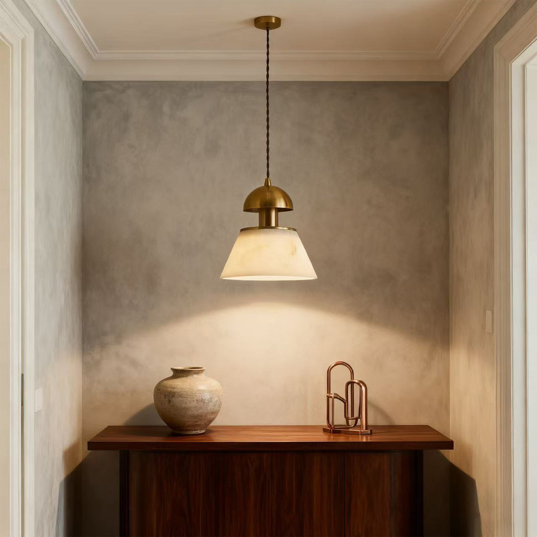 Metallic pendant lights creating focal point in minimalist alcove above wooden cabinet with textured concrete walls