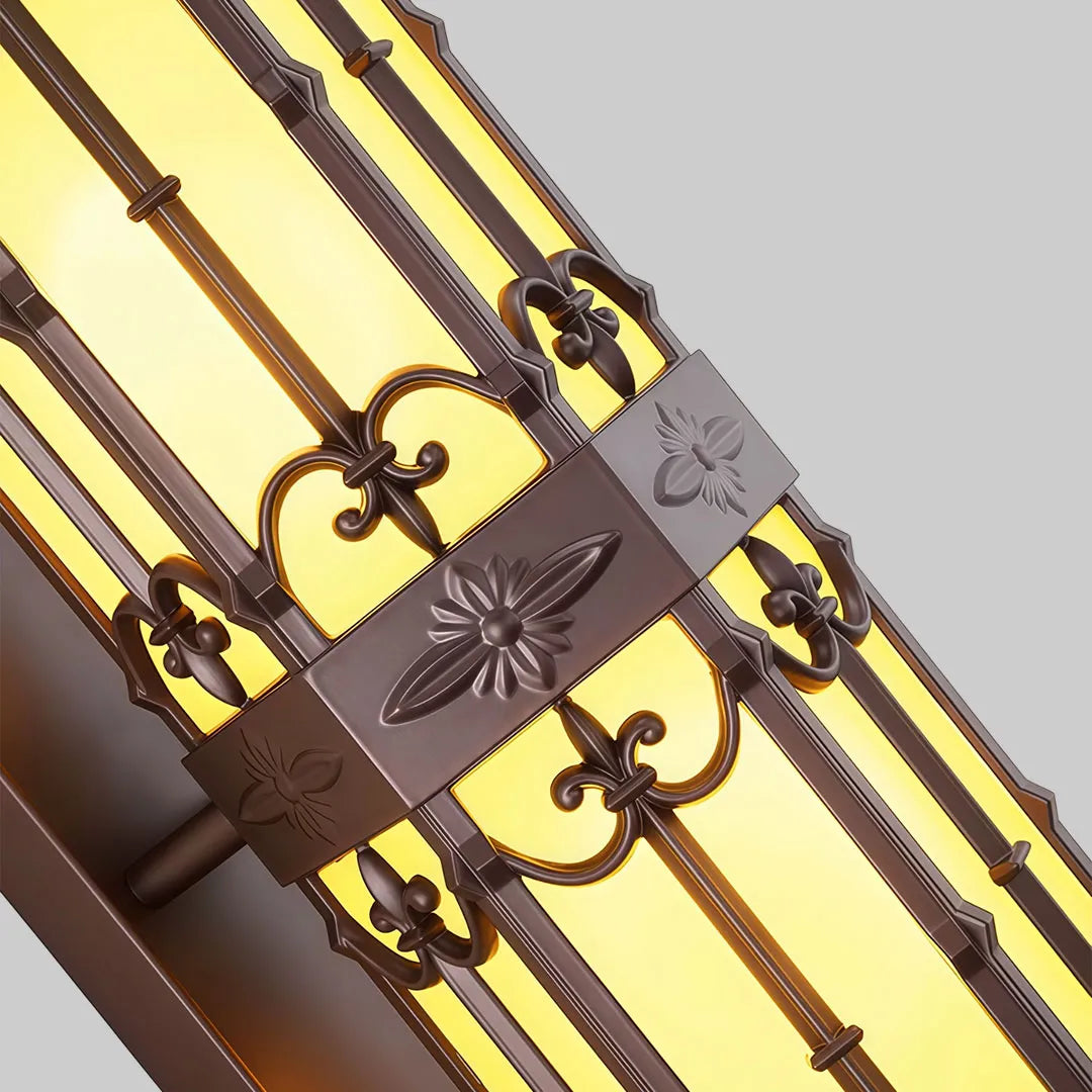Close-up of vintage wall sconce lighting highlighting the decorative metal bars and warm glass panels.