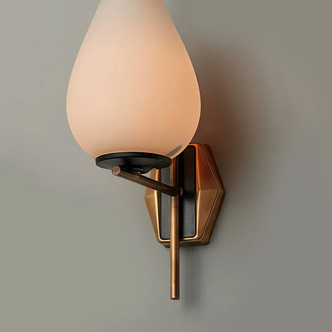 Mid century modern wall light close-up showing the frosted glass shade and brass wall mount.