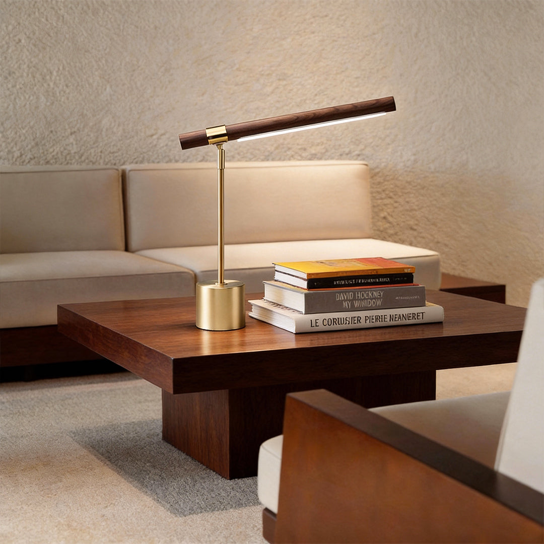 Mid century modern wood and brass lamp providing soft light beside a modern sofa.