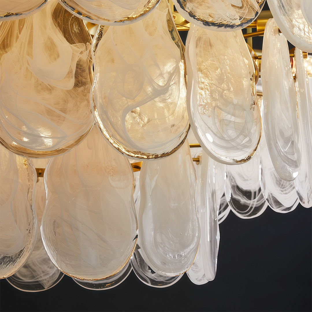Midcentury modern chandelier creating ambient glow in stylish living space with curved sofa.