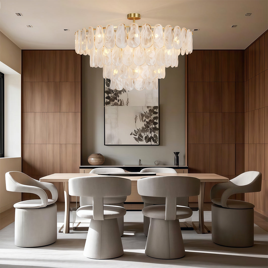 Midcentury modern chandelier illuminating elegant bedroom with upholstered bed and table lamps.