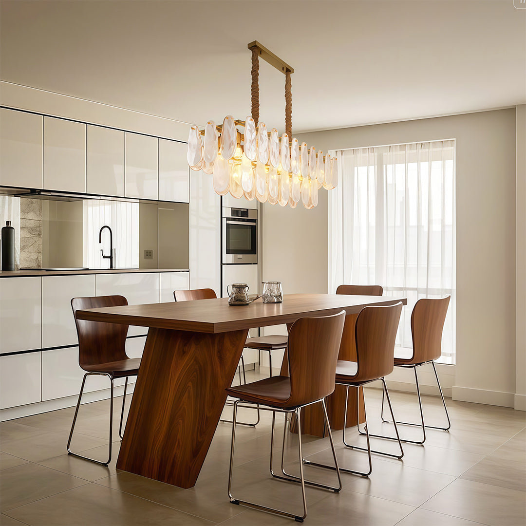 Luxury midcentury modern chandeliers above contemporary round dining table in warm minimalist setting.