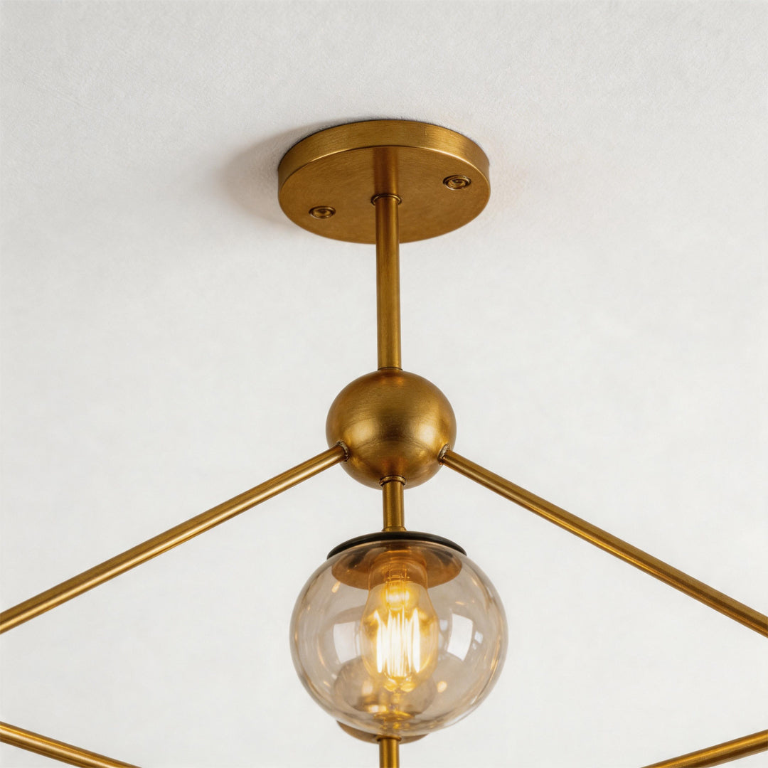 Midcentury modern chandeliers close-up showing brass structure and exposed globe bulb detail.