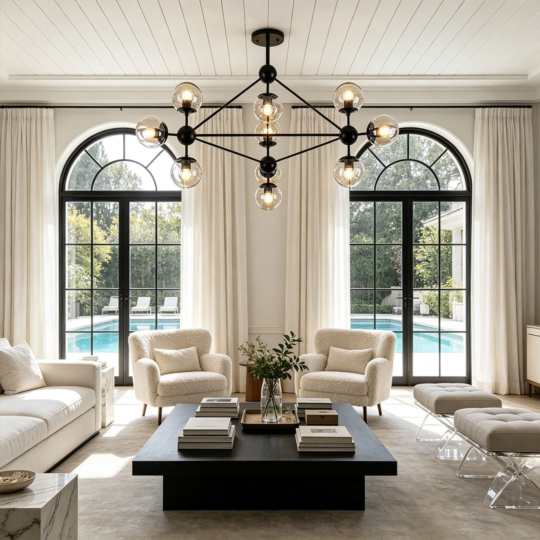 Midcentury modern chandeliers featured in a spacious living room with black metal frame accents.