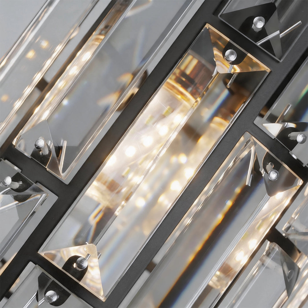 Close-up of illuminated clear crystal elements inside a Mini Crystal Pendant Light with a black metal frame.