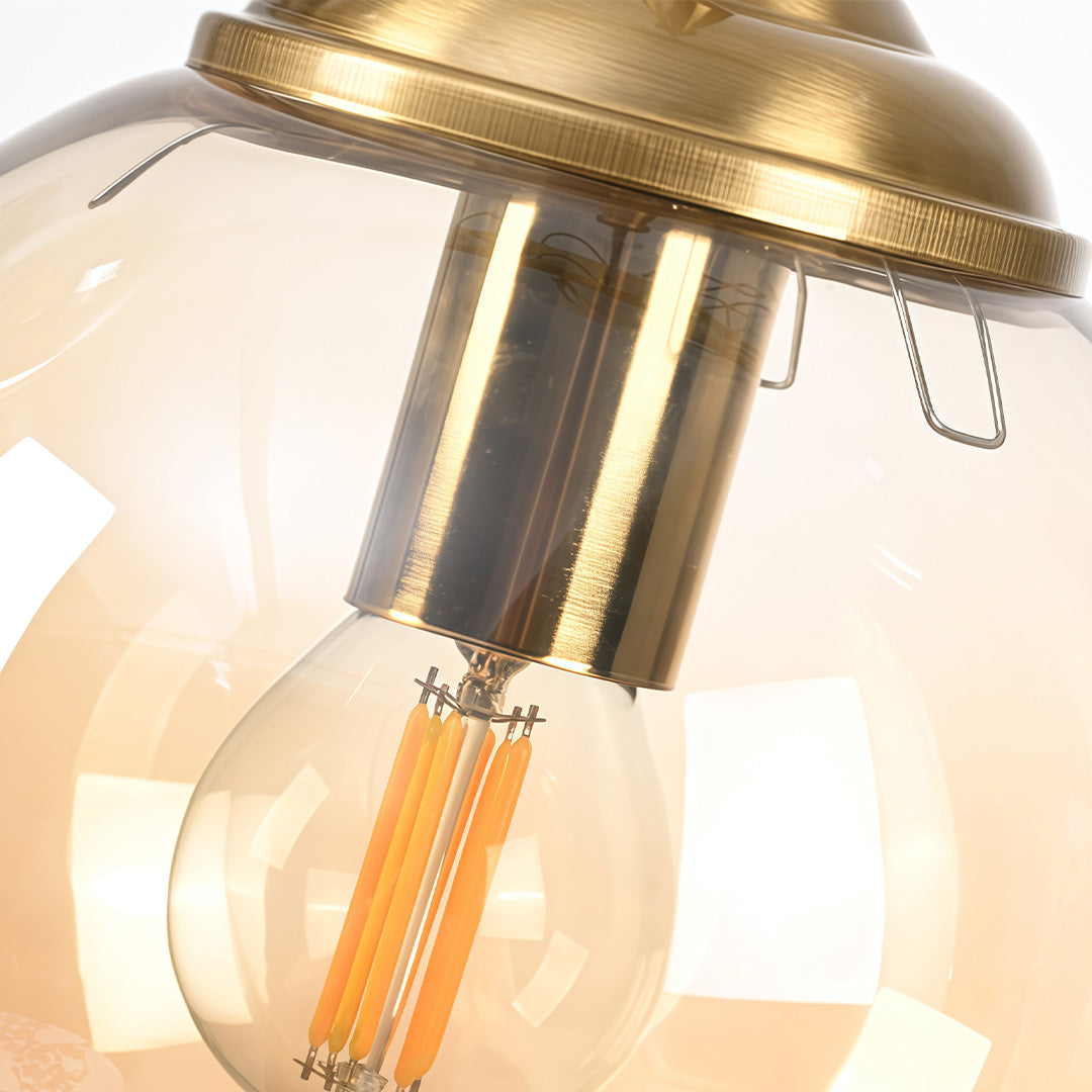 Mini gold pendant light in gold, close-up of the bulb and glass detail.