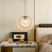 Mini gold pendant light illuminating a modern bedroom with warm, ambient glow.