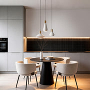 Mini hanging pendant lights installed above a modern dining table, creating warm ambient lighting in a contemporary open kitchen space.