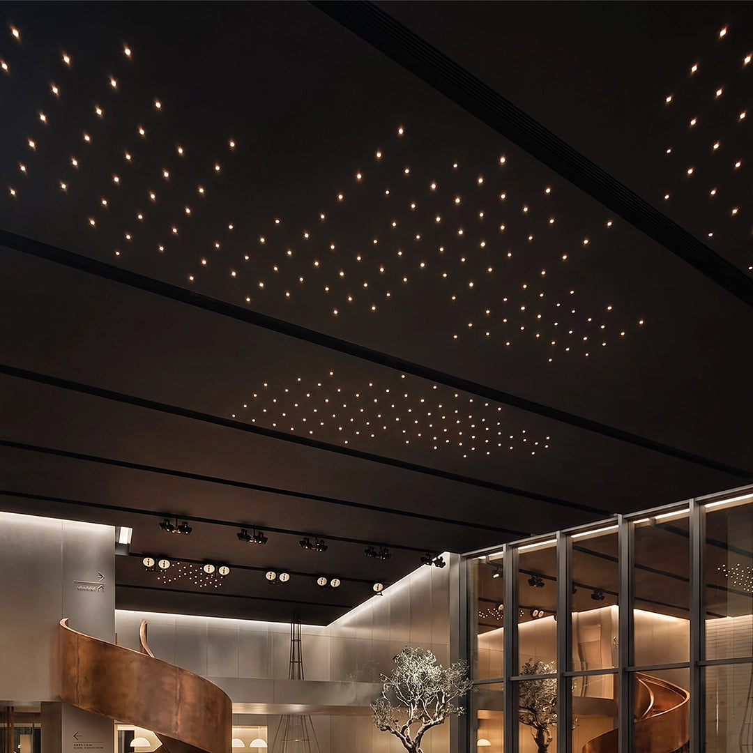 Mini LED spotlight forming a star-like pattern across a dark ceiling in a modern interior.