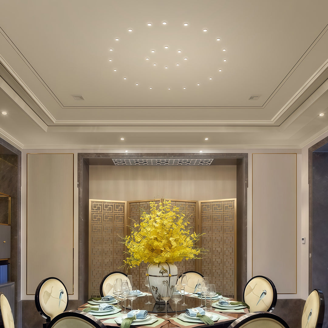 Mini LED spotlights and chandelier brightening elegant dining room with wood paneling and yellow centerpiece