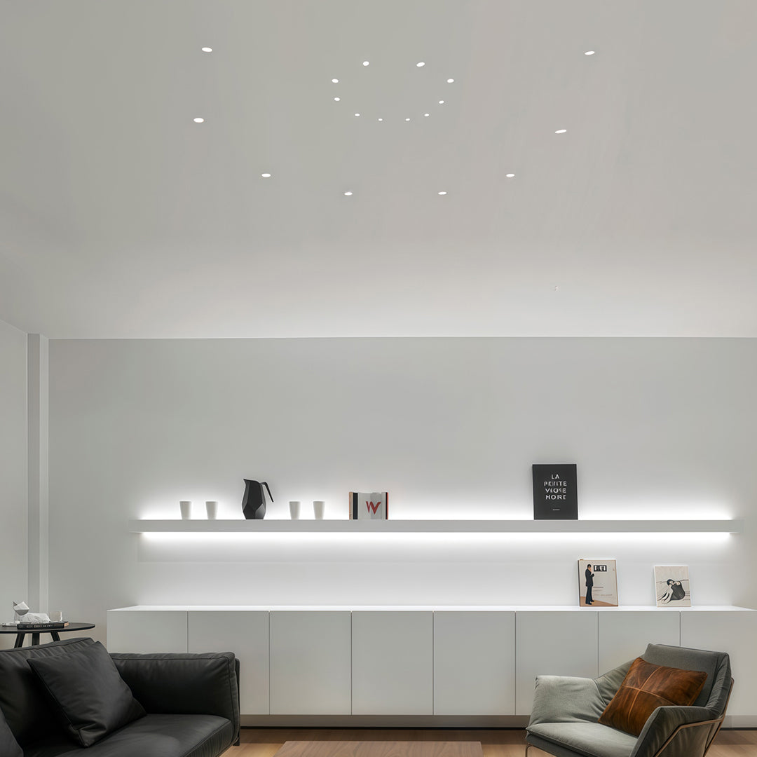 Mini LED spotlights providing task lighting in minimalist white kitchen with sleek cabinetry