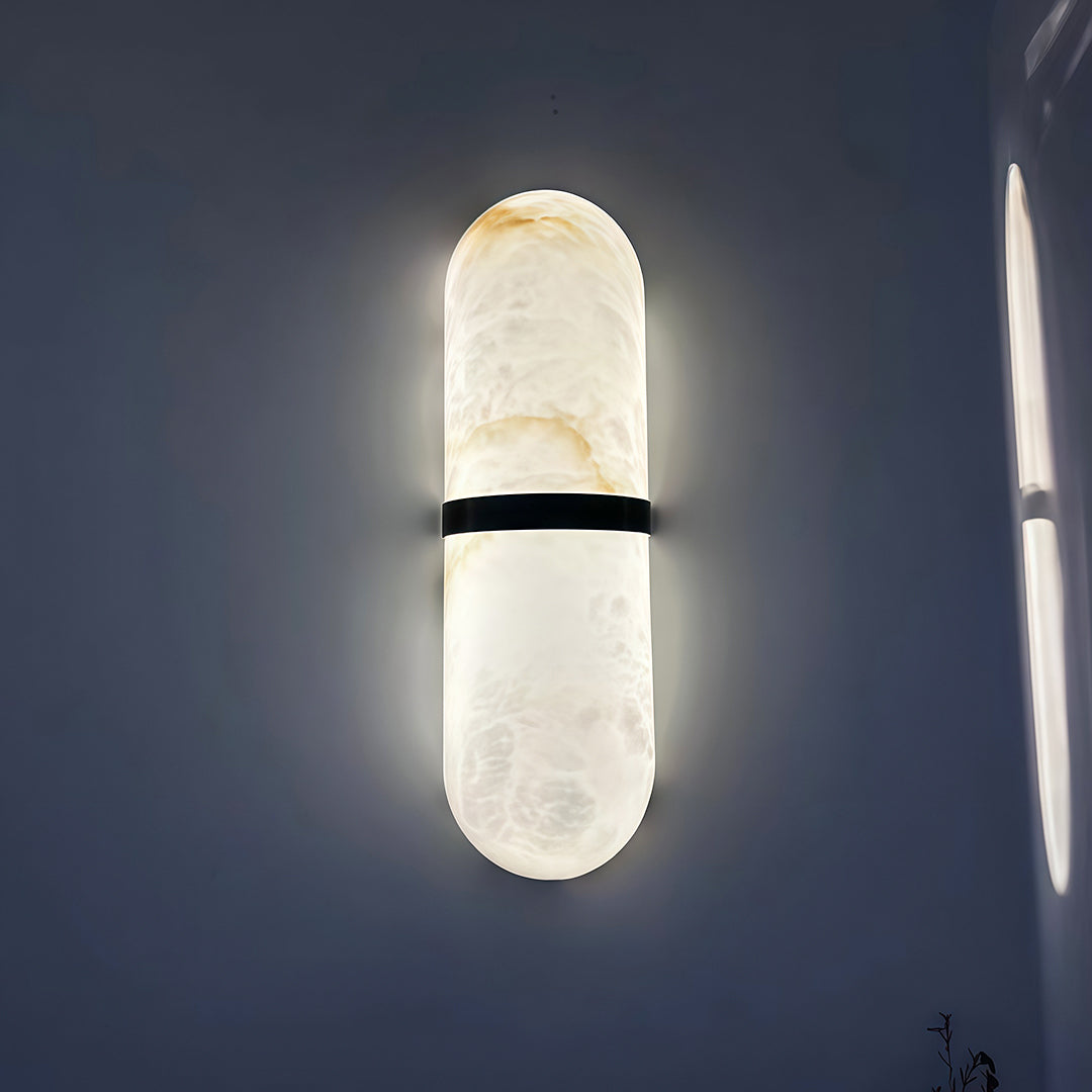 Minimalist art wall lighting featuring glass shade chandelier design providing soft ambient illumination on dark blue accent wall.